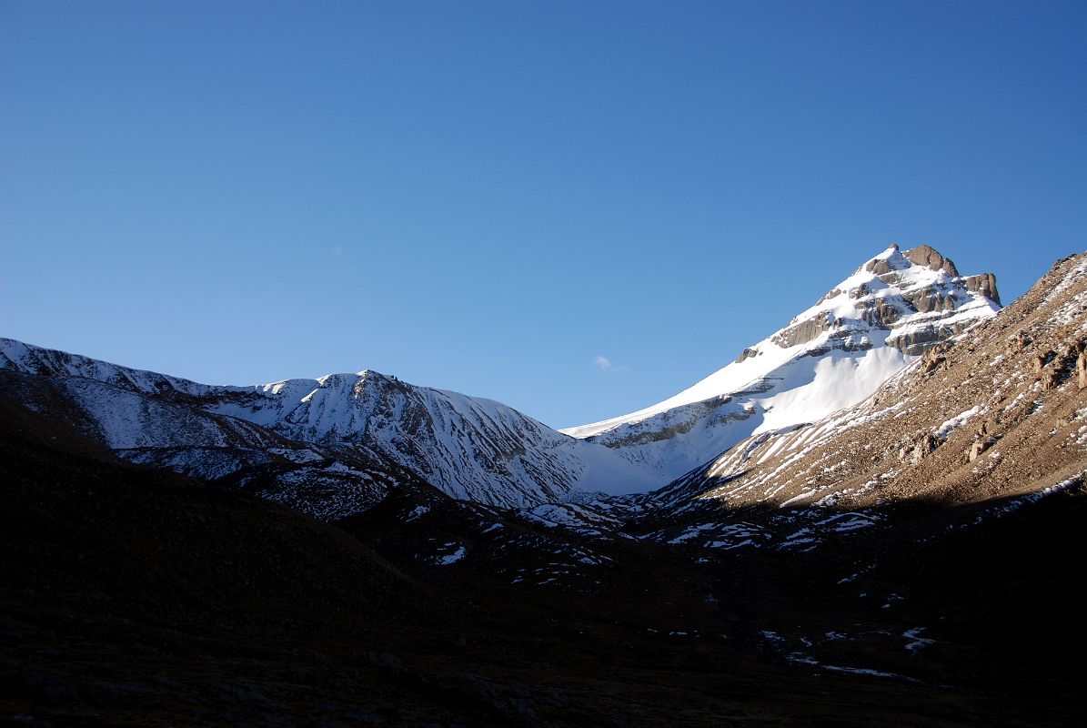 47 Khandro Sanglam La The Secret Path of the Dakini Khandroma Is An Alternative Route Around Mount Kailash In The Early Morning Sun From Shiva Tsal On Mount Kailash Outer Kora Across the valley from Shiva Tsal, a trail branches off to the southeast over the snow-covered Khandro Sanglam La, the Secret Path of the Dakini Khandroma. This alternative route around Kailash bypasses the Dlma La, which tradition says can only be crossed if you have completed 12 previous koras.